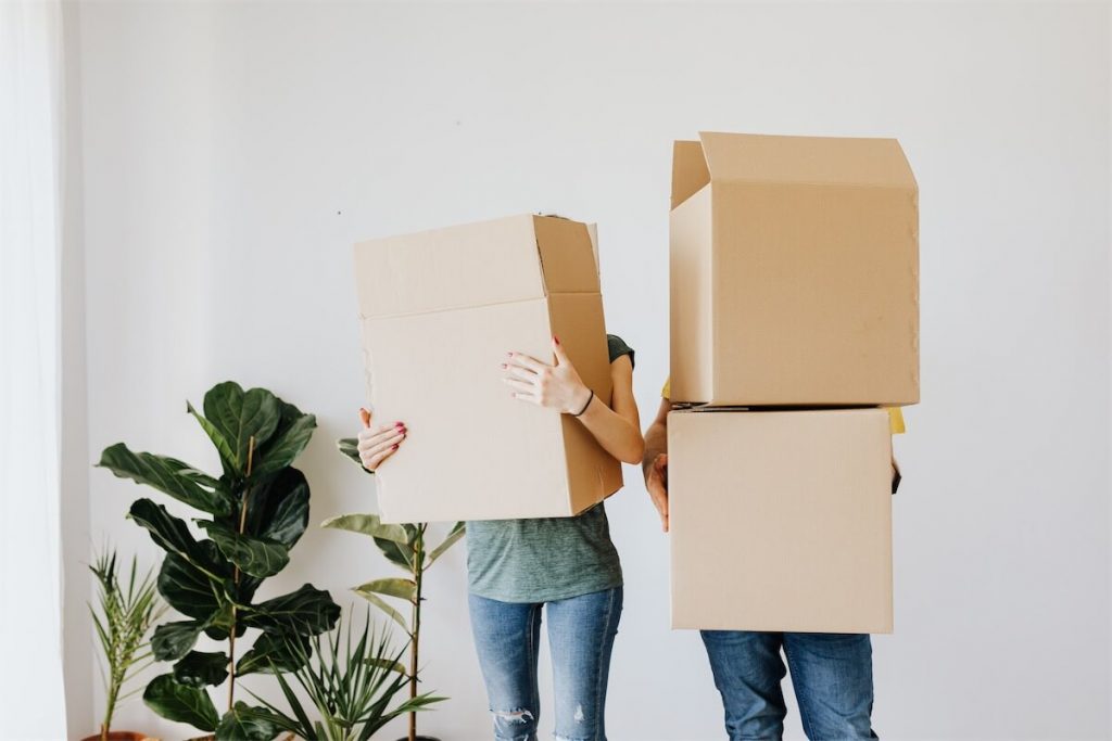 A married couple carrying some boxes in their home and thinking of leveraging the low SIBOR rate by refinancing their home loan