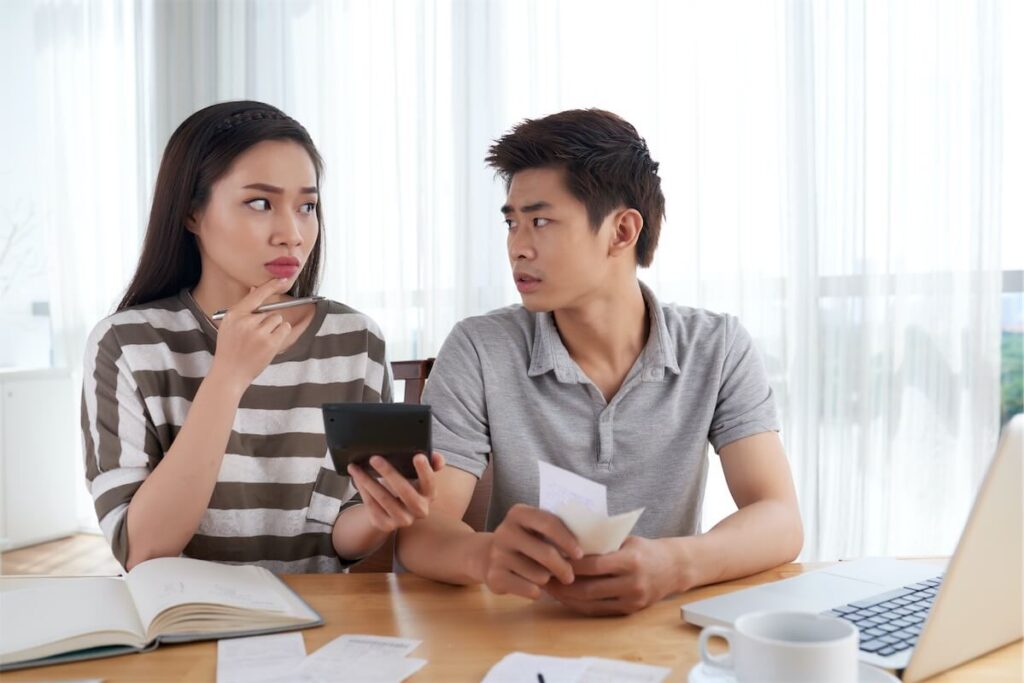 Young couple stressing over how much to borrow for their mortgage loan to afford their dream HDB BTO in Singapore