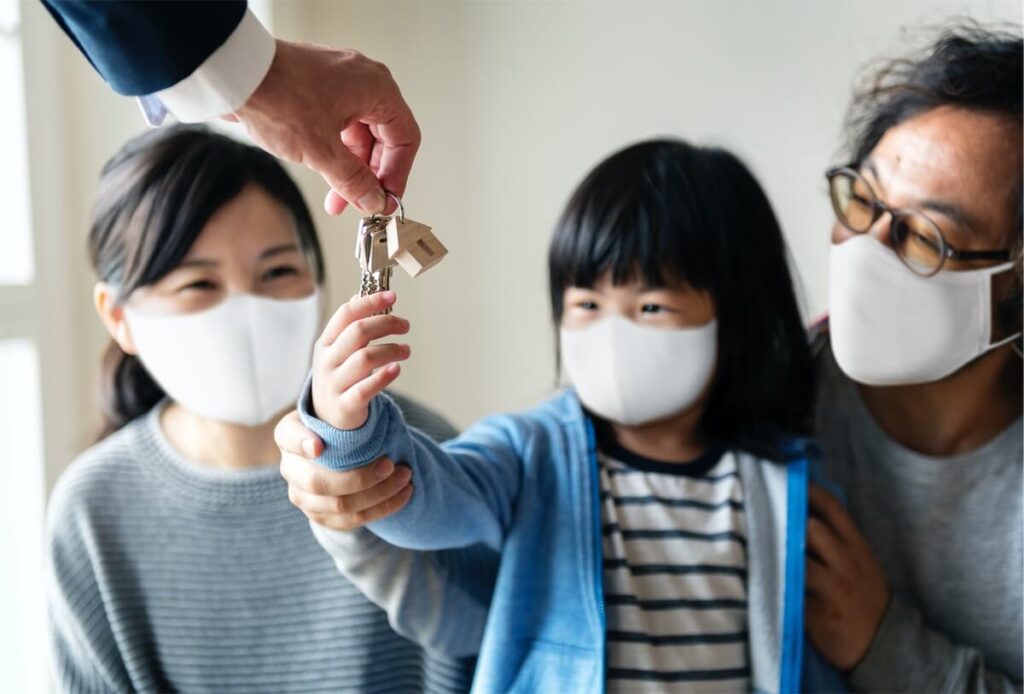 A Singaporean family wearing facial masks and collecting the keys to their house in Singapore located in an affordable estate