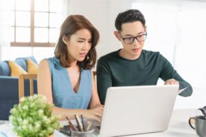 A Singaporean couple in their BTO flat looking at refinancing packages offered in this low-interest-rate environment