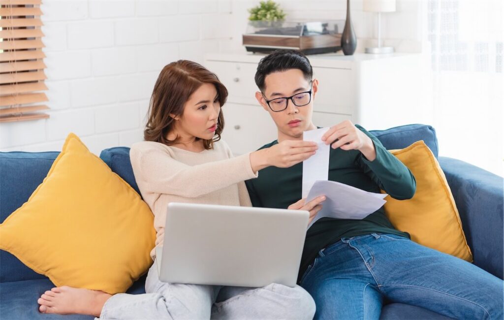 A Singaporean couple looking at their monthly expenses to help with their home loan refinancing decision