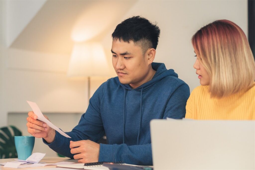 Young couple in Singapore sorting through paperwork for their IPA home loan in Singapore