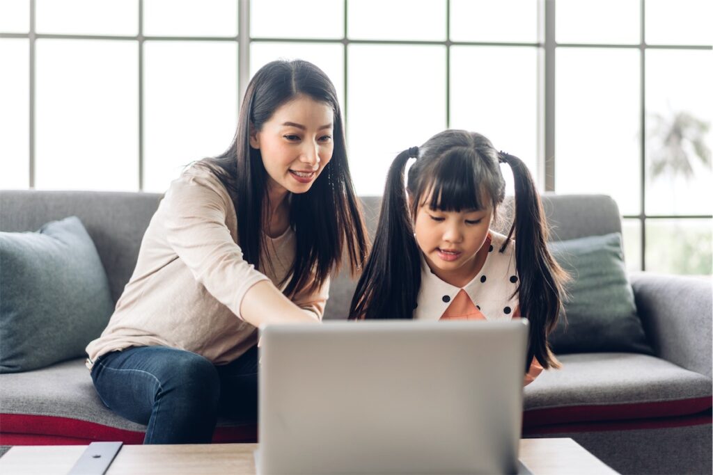 Mother and daughter looking at the laptop, shortlisting potential private property for their next home in Singapore