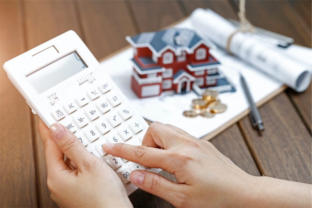 Image of a person using a calculator to calculate rising mortgage interest rise