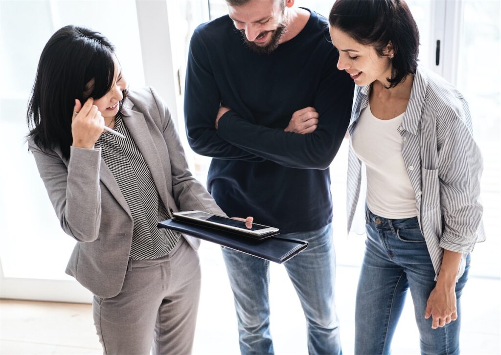 Young Singaporean couple discussing with their mortgage and property agent, looking to grab their private landed property before cooling measures kick in