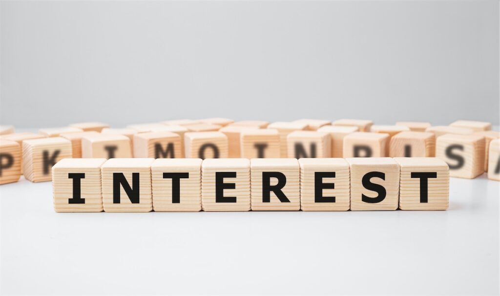 Alphabet blocks spelling “Interest” to show how US Fed rate hikes affect Singapore’s borrowing costs and interest rates