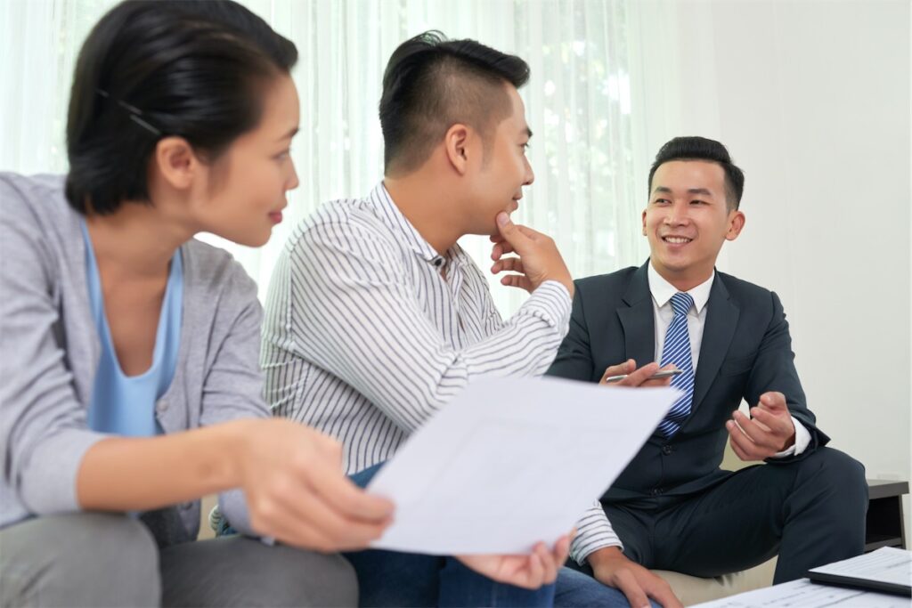 Image of a home loan advisor advising a married couple on their mortgage rates.